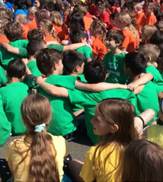 students enjoying a sing along with their arms around each other